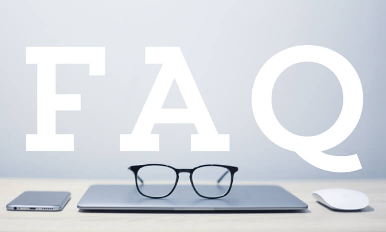 A minimalist desk with a closed laptop, a pair of eyeglasses resting on top, flanked by a smartphone on the left and a computer mouse on the right. The large white text "FAQ" dominates the image background, perfect for cpas near me looking to streamline their workspace.